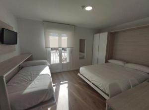 1 dormitorio con 2 camas y TV. en Apartamentos Atempo Aranjuez, en Aranjuez