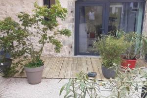 eine Veranda mit Topfpflanzen vor einer Tür in der Unterkunft Gite du Cours St Mauris Authentique et moderne in Dole