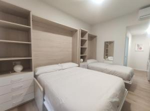 アランフェスにあるApartamentos Atempo Aranjuezの小さな部屋 ベッド2台 棚付