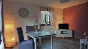 a dining room with a table and a clock on the wall at Villa Moser - Ferienwohnung mit Terrasse in Gera