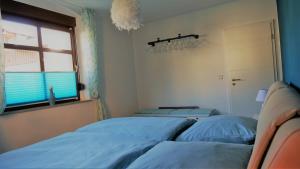 a bedroom with two blue beds and a window at Villa Moser - Ferienwohnung mit Terrasse in Gera