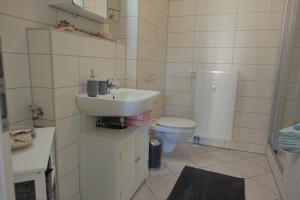 a white bathroom with a sink and a toilet at Villa Moser - Ferienwohnung mit Terrasse in Gera +10 photos