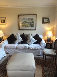 a living room with a white couch with pillows at Chichester Holiday Lets in Chichester