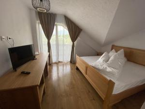 a bedroom with a bed and a desk and a television at Casa Lazaroiu in Curtea de Argeş +74 photos
