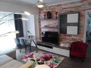 uma sala de estar com um sofá e uma televisão em EL MAR TE ESPERA em Grao de Castellón