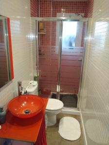 uma casa de banho com um lavatório vermelho e um WC. em EL MAR TE ESPERA em Grao de Castellón