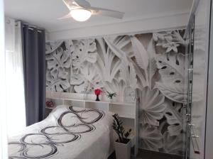 1 dormitorio con 1 cama y papel pintado con motivos florales en EL MAR TE ESPERA, en Grao de Castellón