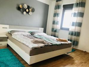 1 dormitorio con 1 cama con ventana y alfombra en FeWo194-Mint Im Herzen von Adenau/Nürburgring, en Adenau