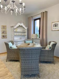 een eetkamer met een tafel en stoelen en een kroonluchter bij Apartamenty Nowe Centrum in Łódź