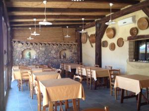 een restaurant met tafels en stoelen en een stenen muur bij Il Ruscello in SantʼAnna Arresi