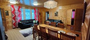 uma sala de estar com um sofá, uma mesa e cadeiras em Lake Cottage Jänisvaara em Kolinkylä