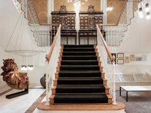 a staircase in a living room with a stair case at Palacio de los Duques Gran Meliá - The Leading Hotels of the World in Madrid