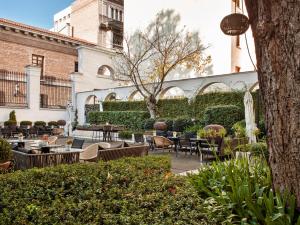 a patio with tables and chairs in a courtyard at Palacio de los Duques Gran Meliá - The Leading Hotels of the World in Madrid