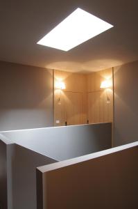La salle de bains est pourvue d'un grand miroir et d'une lampe. dans l'établissement Albergo Rutzer, à Asiago