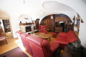 ein Wohnzimmer mit roten Möbeln und einem Kamin in der Unterkunft Chez Jean Pierre - Couple room in a 17th century house - n 1 in Villar-dʼArène