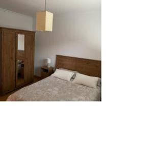 a bedroom with a bed with a wooden head board at 8 de abril in Los Corrales de Buelna