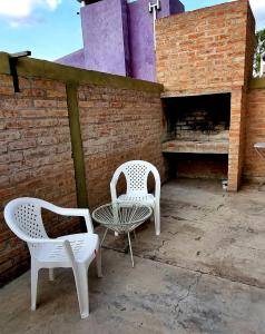 two white chairs and a table on a patio at Duplex Boulevard D in Viedma