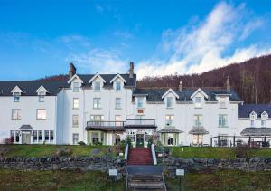 un grande edificio bianco con una scala di fronte di Loch Rannoch Hotel and Spa a Kinloch Rannoch