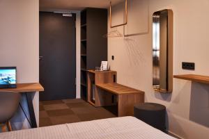 een kamer met een bed, een bureau en een deur bij Novitel Hotel Kirchheim - München Messe in Kirchheim