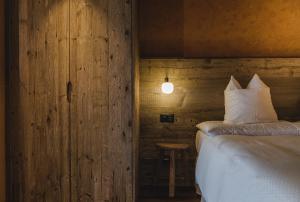 1 dormitorio con 1 cama y pared de madera en the rex, en Zermatt