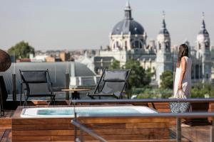 a woman standing on the roof of a building at Palacio de los Duques Gran Meliá - The Leading Hotels of the World in Madrid