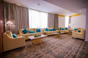 - un grand salon avec des canapés et des oreillers bleus dans l'établissement Le Park Concord Hotel & Resident Najran, à Najran