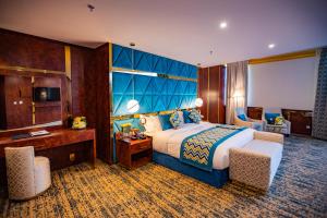 納季蘭的住宿－Le Park Concord Hotel & Resident Najran，一间卧室配有一张大床和蓝色床头板