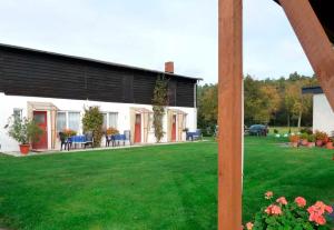 une maison avec une pelouse verte devant elle dans l'établissement Ferienwohnung Tor zur Ostsee - a55964, à Mellenthin