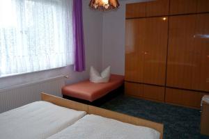 1 dormitorio con 1 cama, 1 silla y 1 ventana en Ferienwohnung Tor zur Ostsee - a55964, en Mellenthin
