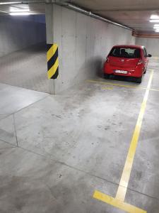 a red car parked in a parking garage at Apartament Skarbowa in Leszno
