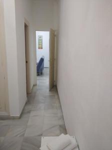 a hallway with white walls and a hallway with at Apartamento San Miguel Caballeros in Jerez de la Frontera