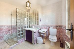 a bathroom with a toilet and a sink and a shower at Agro da Gandarela in Teo