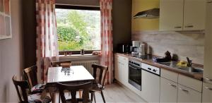 cocina con mesa, fregadero y ventana en FeWo Krehberg, en Lindenfels