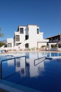 a large swimming pool in front of a house at Golf Dreams in San Miguel de Abona