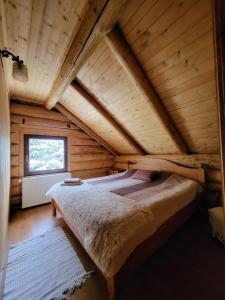 a bedroom with a bed in a wooden house at Cabana Lupilor in Tău Bistra