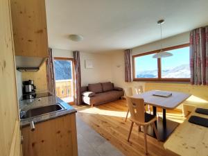 a kitchen and living room with a table and a couch at Zimmererhof in Bressanone