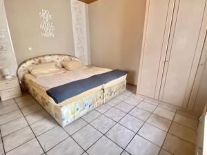 a bed in a bedroom with a tiled floor at 19 Im Herrenfeld in Burgen