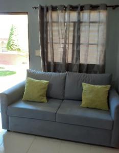 1 sofá azul con 2 almohadas amarillas en la sala de estar en CASITA HOGAREÑA JARABACOA (independent entrance) en Jarabacoa