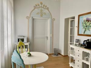 uma sala de jantar com uma mesa branca e um espelho em Lovely studio in a villa from 18th century em Thun