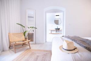Assumar Country House في Assumar: غرفة معيشة بيضاء مع قبعة على أريكة