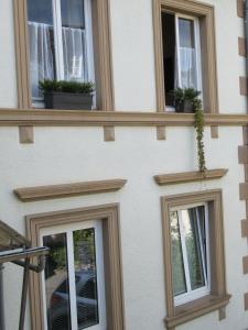 a building with three windows with potted plants on it at Ferienhaus Berkele für 8 bis 12 Personen in Neumagen-Dhron