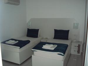 two beds in a small room with towels on them at Teos Hotel in Antalya