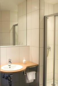 ein Bad mit einem Waschbecken und einer Dusche in der Unterkunft Einhaus Jägerhof in Dorsten