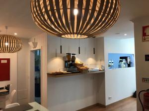 a kitchen with a large chandelier hanging from the ceiling at Real Caparica Hotel in Costa da Caparica
