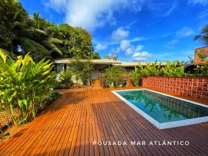 ein Haus mit einem Pool auf einer Holzterrasse in der Unterkunft Pousada Mar Atlântico in Fernando de Noronha
