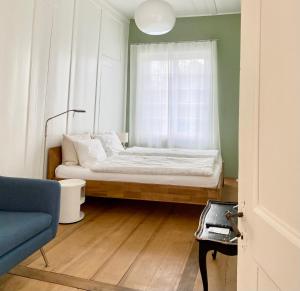 ein kleines Schlafzimmer mit einem Bett und einem Fenster in der Unterkunft Lovely studio in a villa from 18th century in Thun