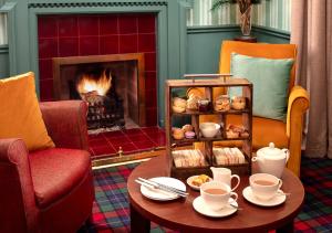 a living room with a fireplace and a table with coffeeisers at Loch Rannoch Hotel and Estate in Kinloch Rannoch