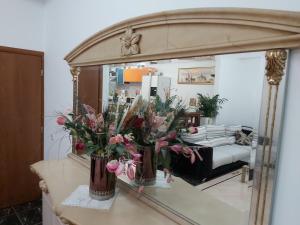 a mirror with two vases with flowers on a counter at Villa NIKITA sunrise sea view in Koskinou
