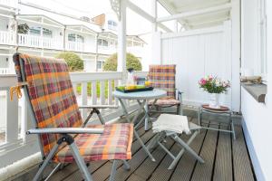 um pátio com 2 cadeiras e uma mesa na varanda em Strandvilla Seeadler hinter Düne und Meer em Binz