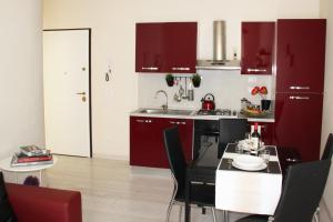 una cocina con armarios rojos y una mesa con sillas. en Sant'Antonino Apartment, en Florencia